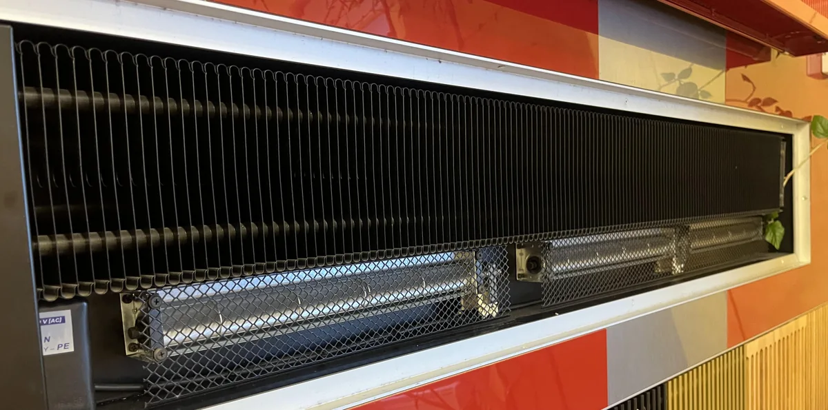 Cross-flow blower inside an air curtain over a doorway